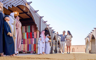 Couple exploring market stalls at Noble Camp Desert Safari.