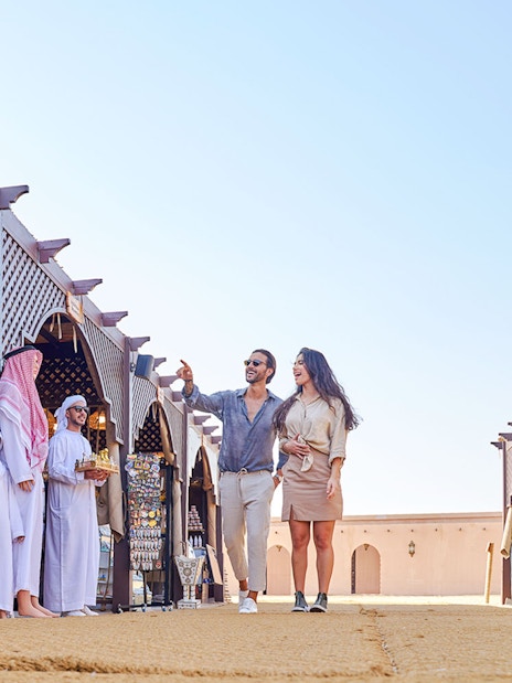 Couple exploring market stalls at Noble Camp Desert Safari.