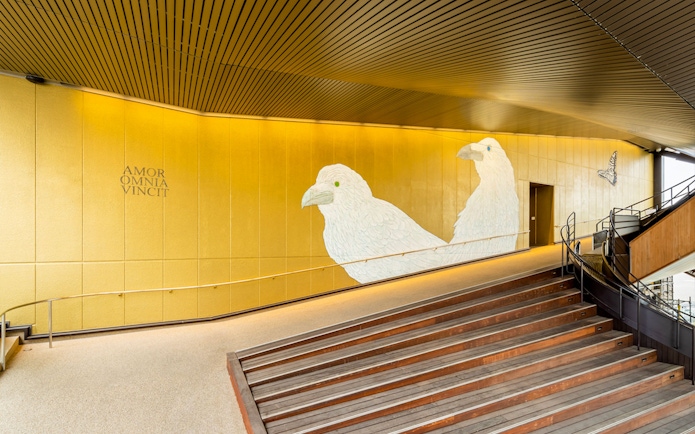 Hiroshima Orizuru Tower interior with bird mural and staircase.