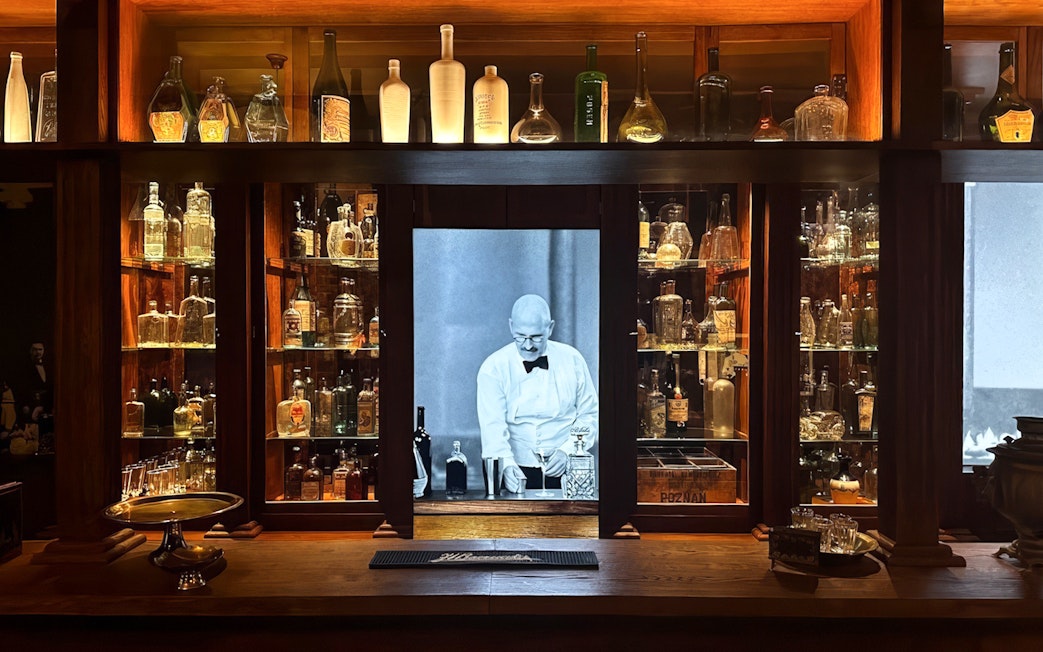 Vodka bottles displayed at Krakow Vodka Factory Museum with bartender image.