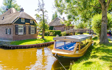 Canal boat near traditional thatched houses in Giethoorn, Netherlands.
