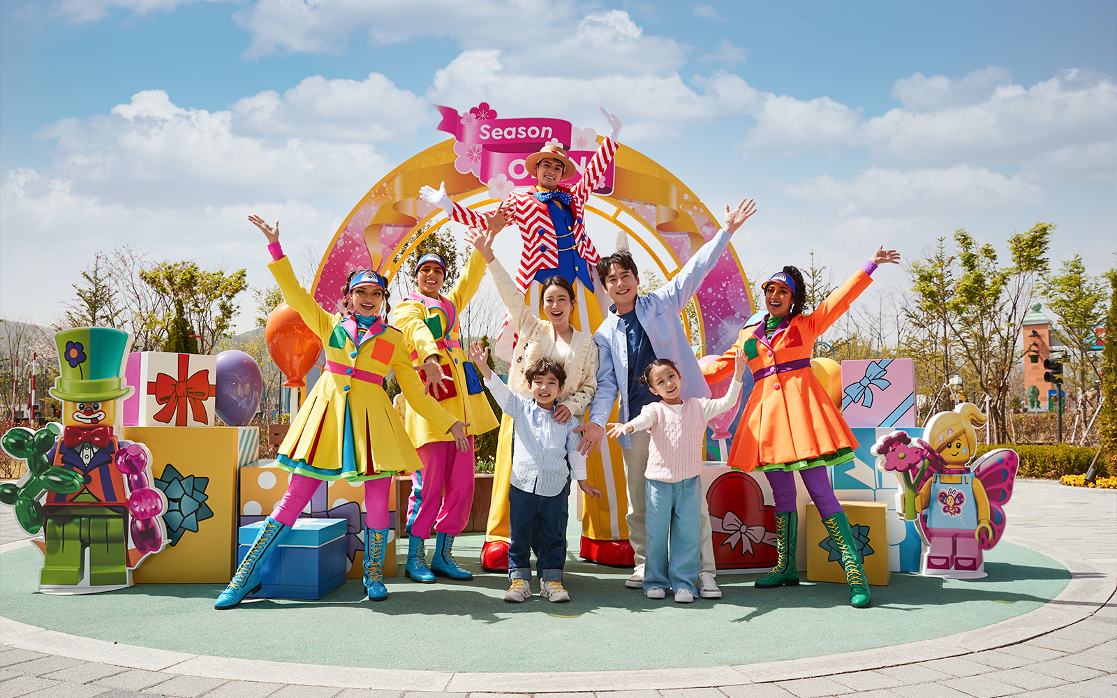 Family enjoying Legoland Korea with colorful performers and LEGO decorations.