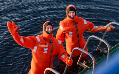 Participants in orange survival suits during Icebreaker Cruise, Rovaniemi.