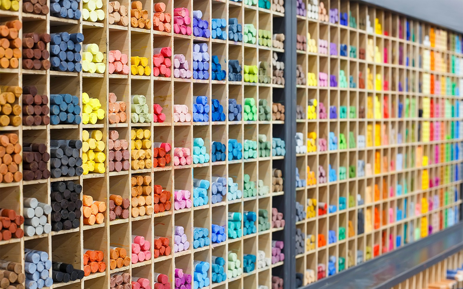 Multicolored pastel crayons displayed in store shelves, closeup view.
