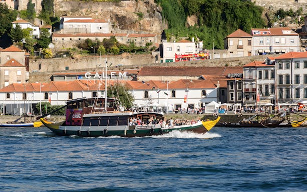 Tour boat cruising on the Douro River with Porto's historic waterfront in the background.