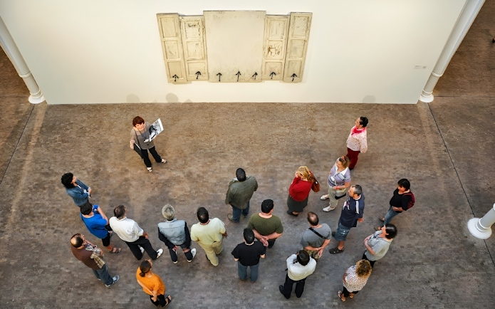 Group tour at Fundació Antoni Tàpies, Barcelona, viewing artwork on a gallery wall.