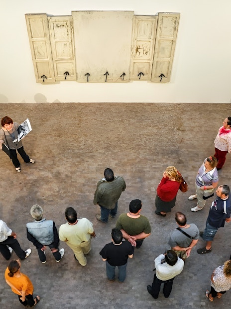 Group tour at Fundació Antoni Tàpies, Barcelona, viewing artwork on a gallery wall.