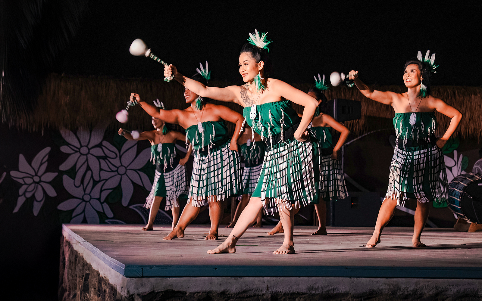 Traditional Polynesian women performing Poi dance on stage.