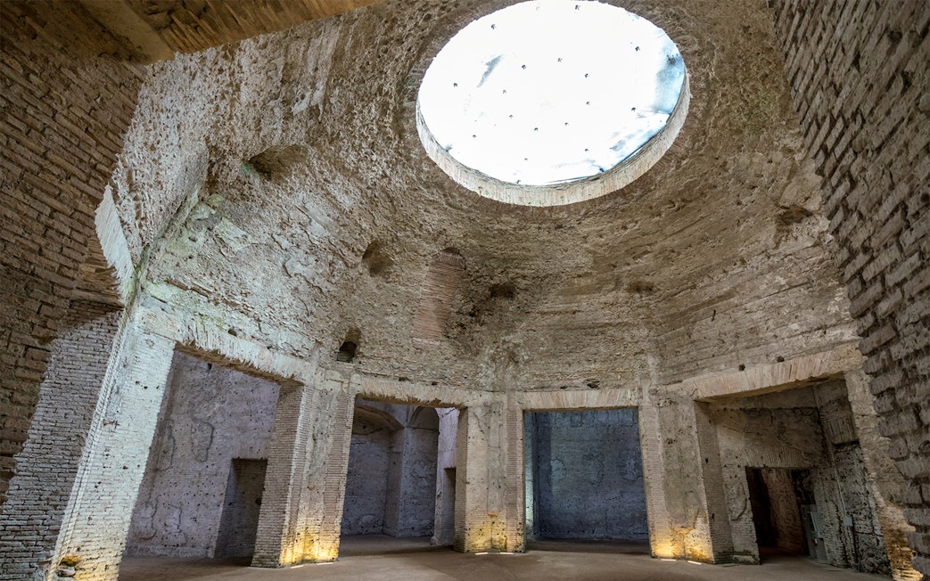 Domus Aurea interior with ancient Roman brickwork and large oculus in Rome, Italy.