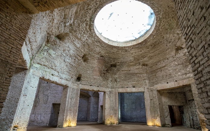 Domus Aurea interior with ancient Roman brickwork and large oculus in Rome, Italy.