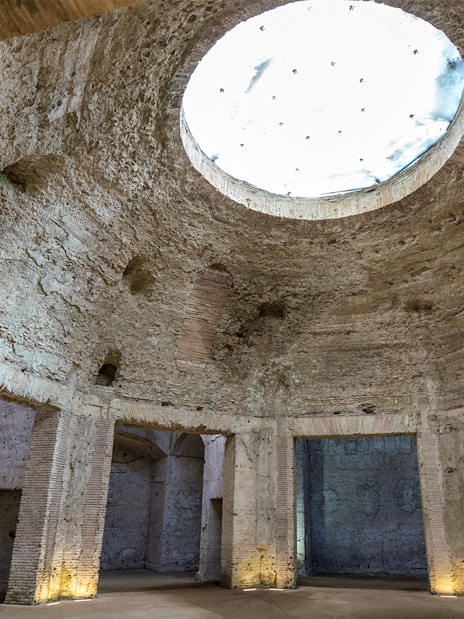 Domus Aurea interior with ancient Roman brickwork and large oculus in Rome, Italy.