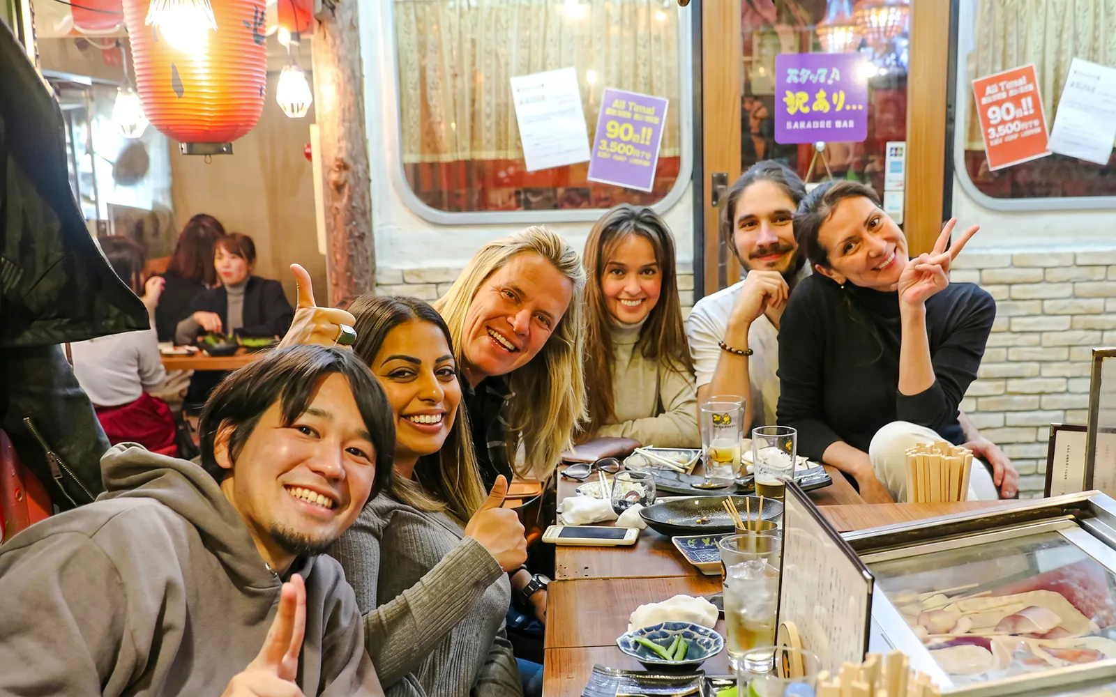 Group enjoying dinner and drinks at a bar in Shinjuku, Tokyo.