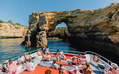 Sightseeing boat approaching Benagil Caves on Algarve coast during 3-hour cruise from Albufeira.