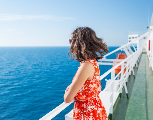 Woman enjoying ocean view from ferry deck.