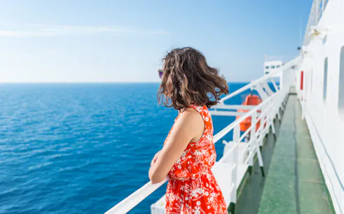 Woman enjoying ocean view from ferry deck.