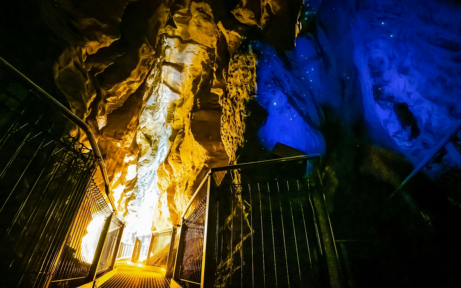 Walkway inside Ruakuri Cave with illuminated rock formations, Waitomo, New Zealand.