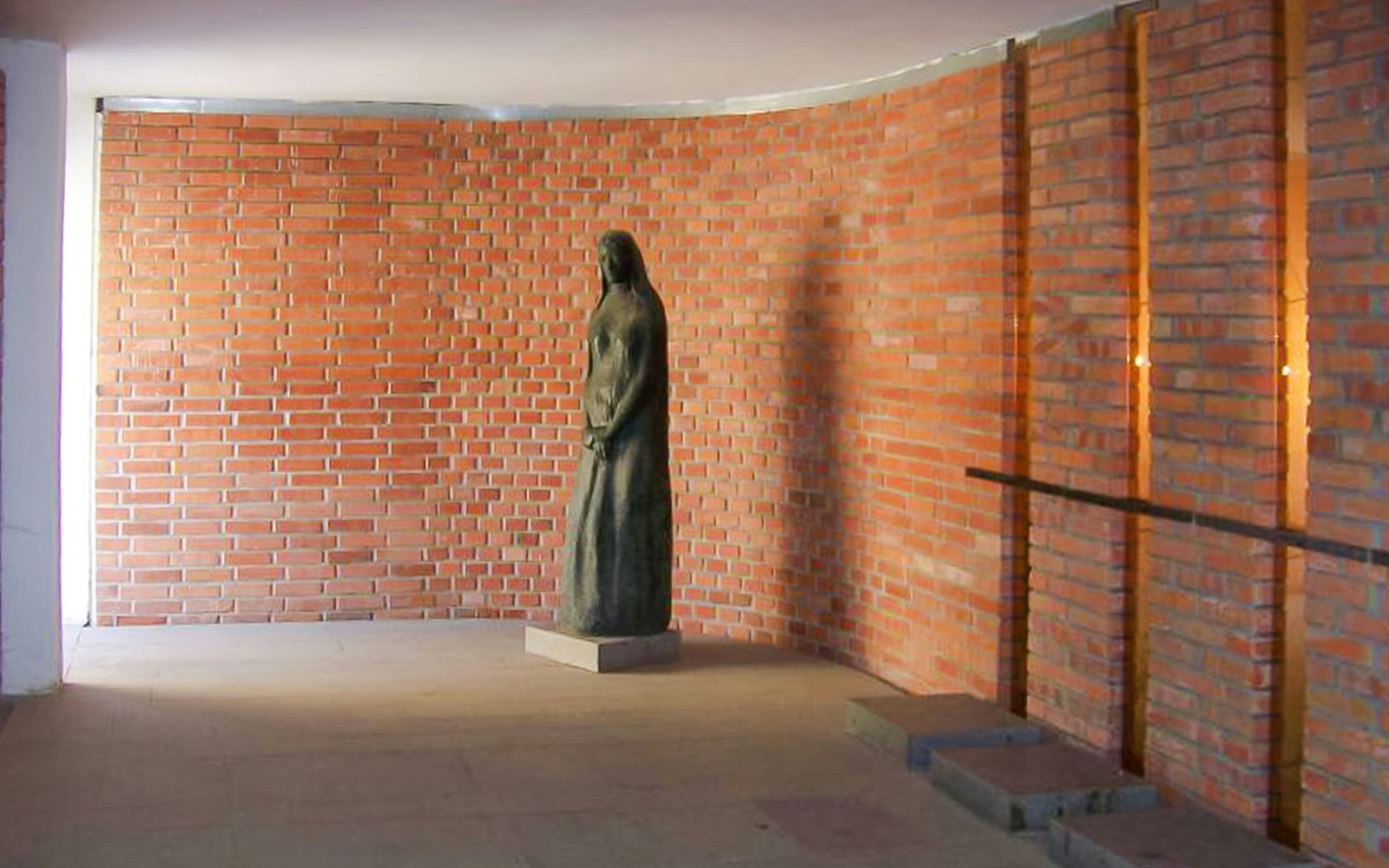 Statue inside Terezin Concentration Camp against a brick wall.