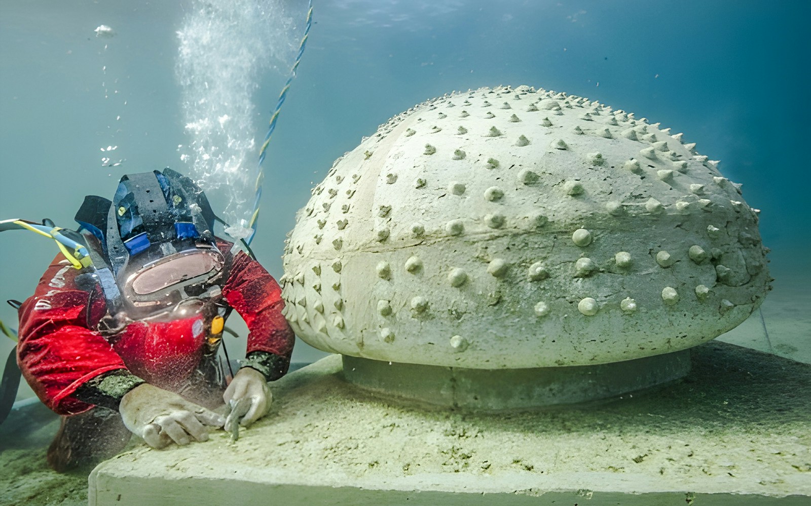 Diver examining sculpture at Underwater Museum of Marseille.