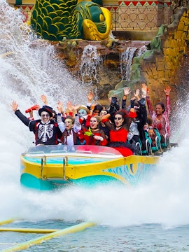 Visitors in costumes enjoying a water ride at Gardaland Park.