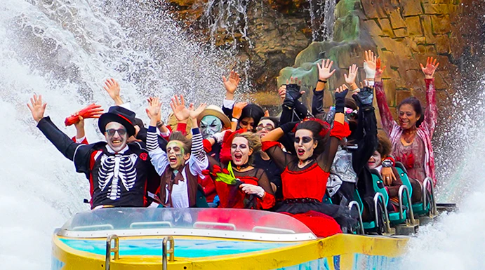 Visitors in costumes enjoying a water ride at Gardaland Park.