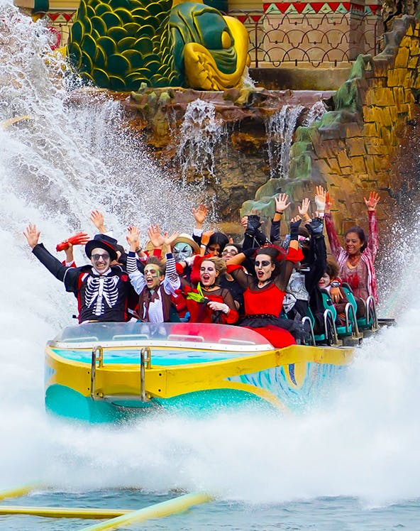 Visitors in costumes enjoying a water ride at Gardaland Park.