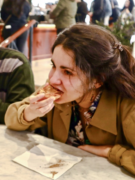 Tour group enjoying Pastel de Nata on Lisbon food tour.