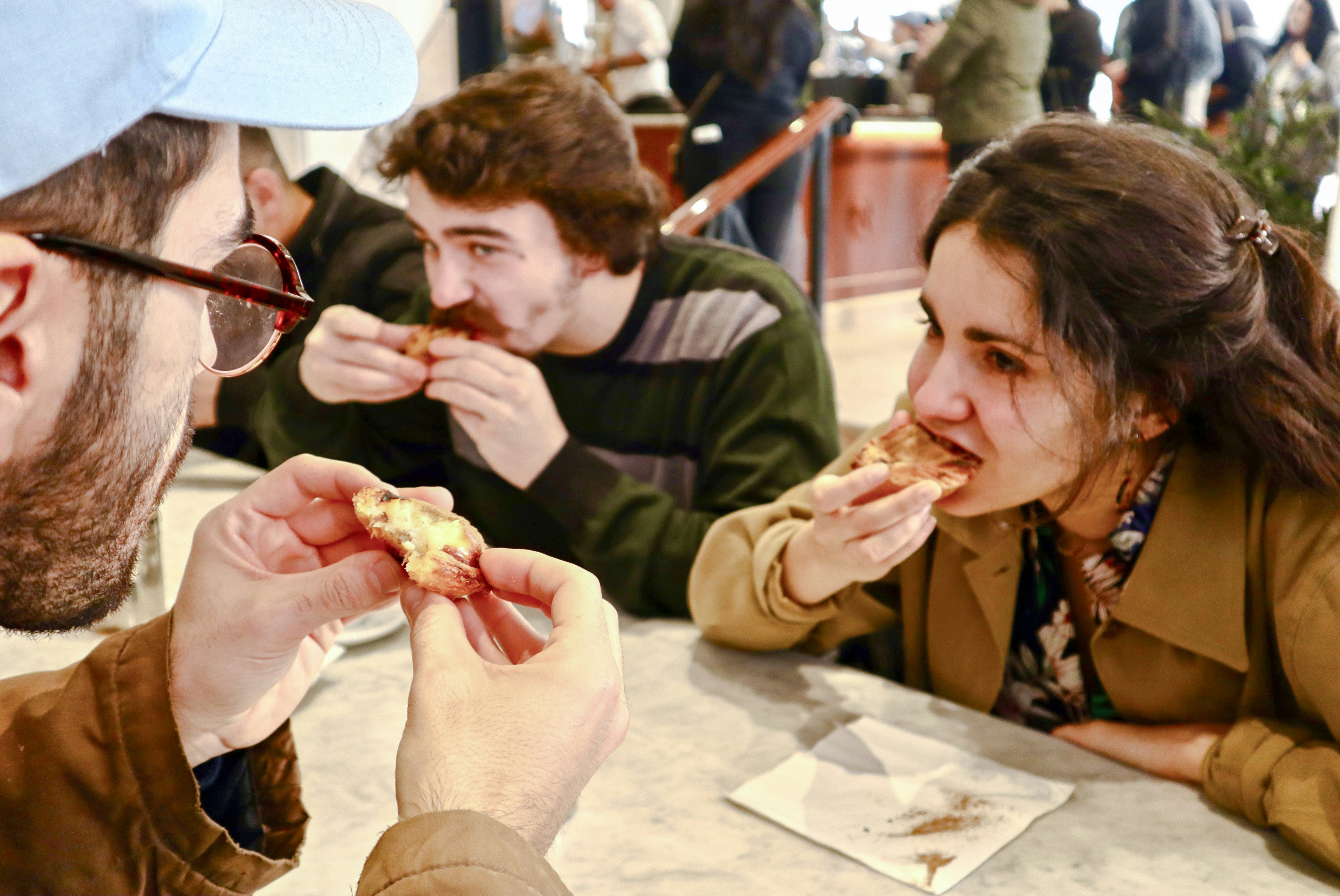 Tour group sampling Pastel de Nata on Lisbon food tour.