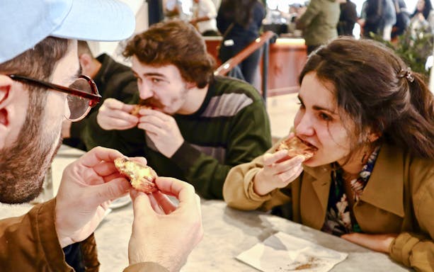 Tour group enjoying Pastel de Nata on Lisbon food tour.