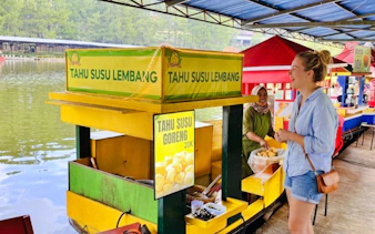 Floating market vendor selling Tahu Susu Lembang in Bandung, Indonesia.