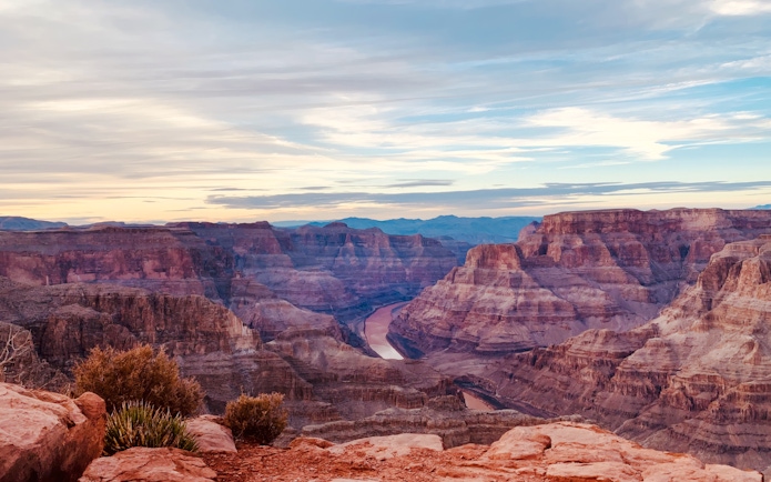 Grand Canyon view with layered rock formations and Colorado River below.