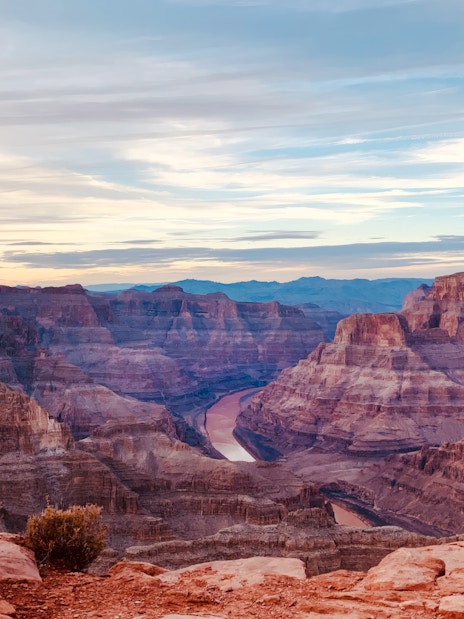 Grand Canyon view with layered rock formations and Colorado River below.