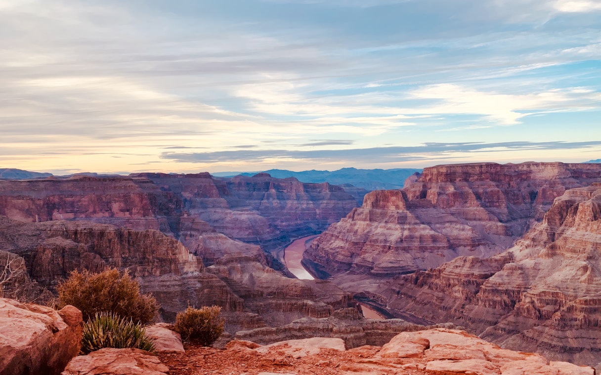 Grand Canyon view with layered rock formations and Colorado River below.