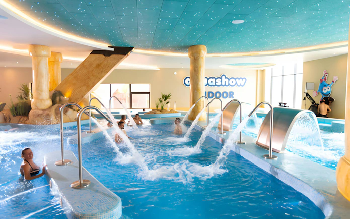 Visitors enjoying water jets at Aquashow Indoor Park pool.