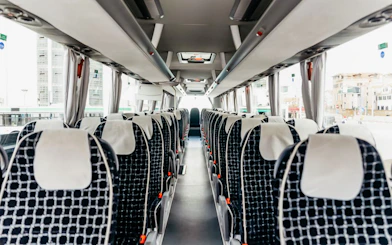 Interior of ATVO Airport transfer bus with rows of empty seats.