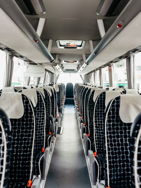 Interior of ATVO Airport transfer bus with rows of empty seats.
