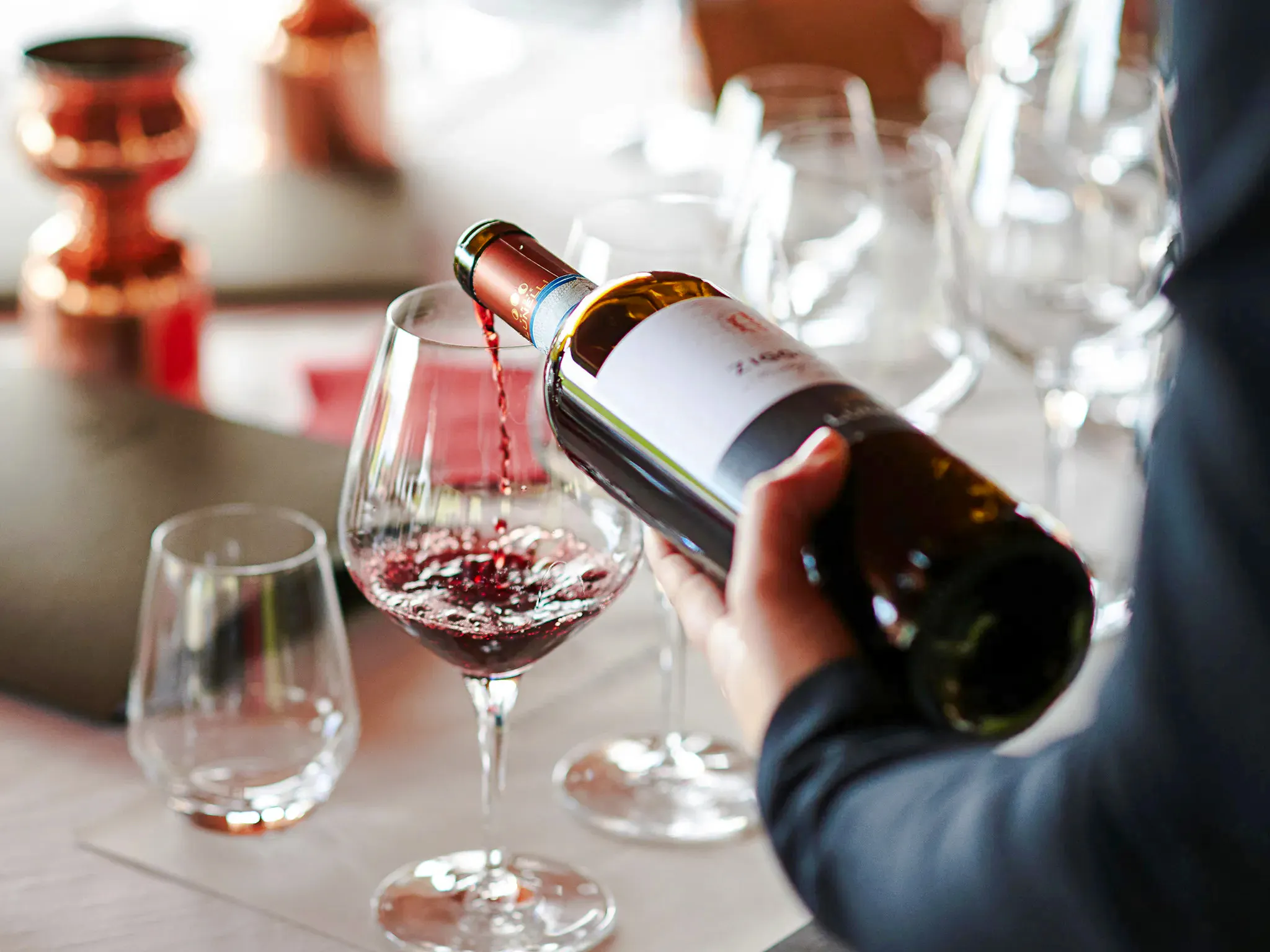 Pouring red wine into a glass during a Brazilian wine tasting in Rio de Janeiro.