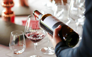 Pouring red wine into a glass during a Brazilian wine tasting in Rio de Janeiro.