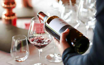 Pouring red wine into a glass during a Brazilian wine tasting in Rio de Janeiro.