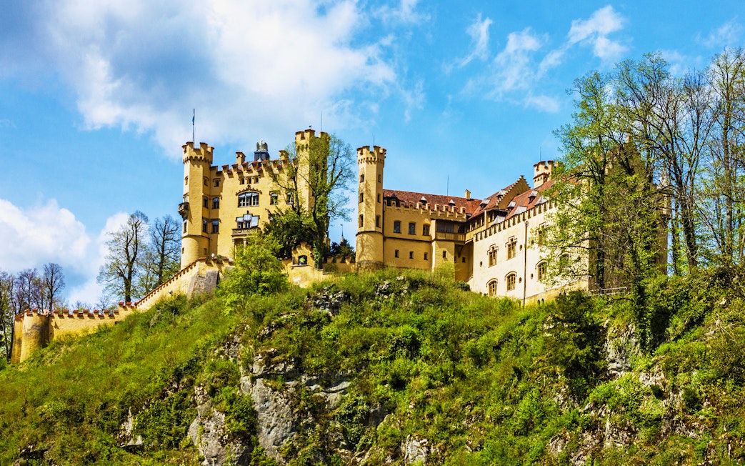 Hohenschwangau Castle on a hill surrounded by trees, Bavaria, Germany.