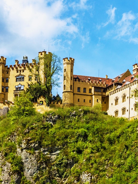 Hohenschwangau Castle on a hill surrounded by trees, Bavaria, Germany.