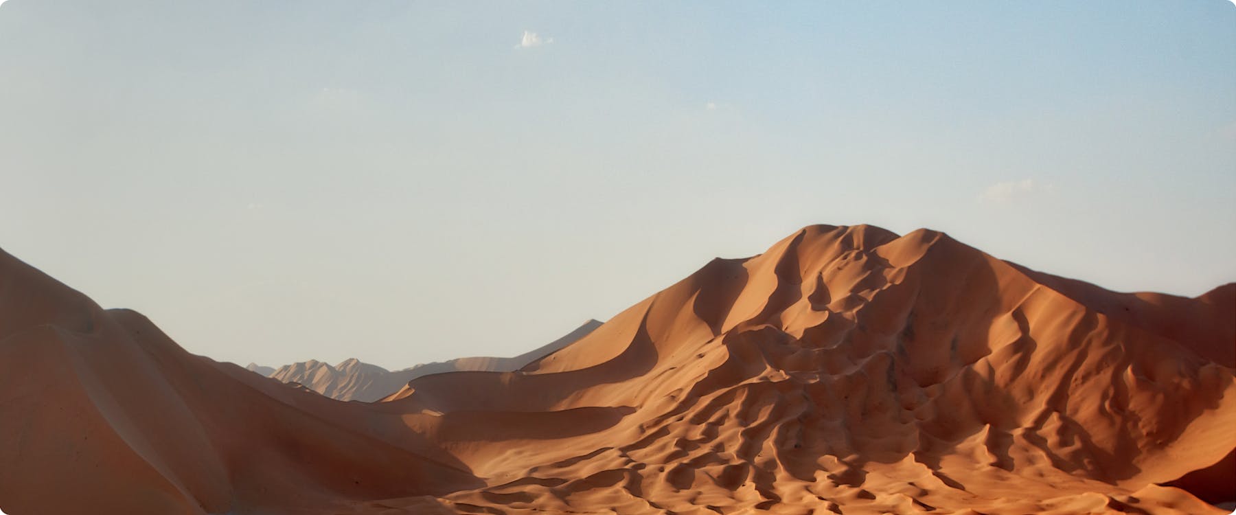 Sand dunes in Sakhir desert under clear sky.