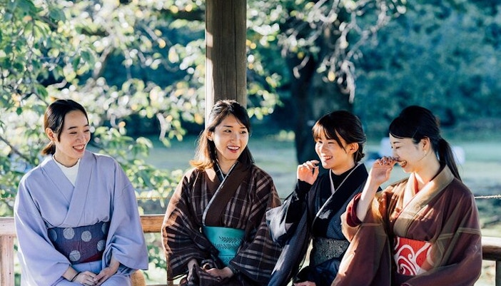 Tourists in kimonos enjoying Tokyo Matcha & Kimono Experience outdoors.