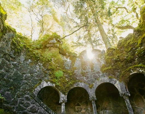 Quinta da Regaleira well view with intricate stone spiral staircase in Sintra, Portugal.