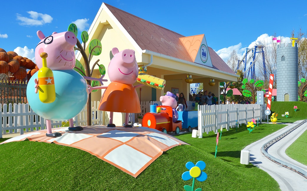 Peppa Pig characters at Gardaland Park attraction with colorful scenery.