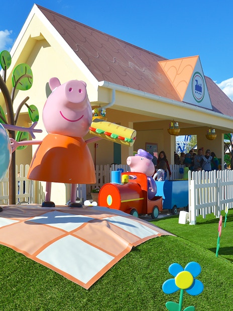 Peppa Pig characters at Gardaland Park attraction with colorful scenery.