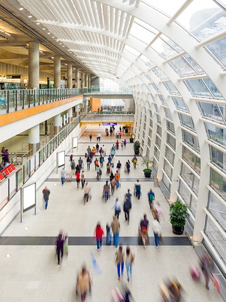 Passengers walking in Hong Kong airport terminal for express transfers.