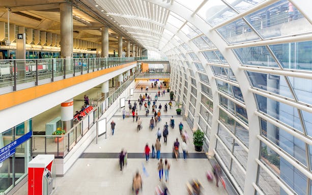Passengers walking in Hong Kong airport terminal for express transfers.