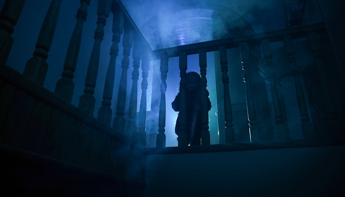 Child in eerie lighting on staircase
