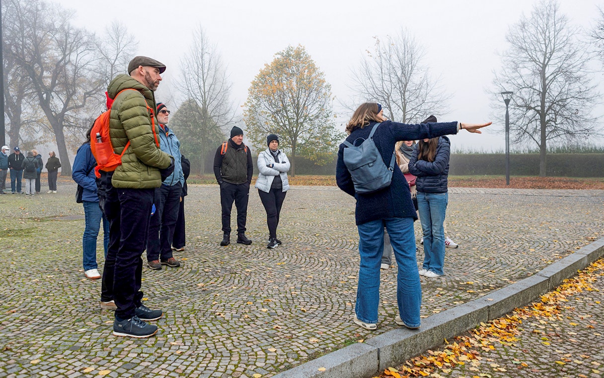 Tour guide explaining to tourists during Terezin Concentration Camp tour.