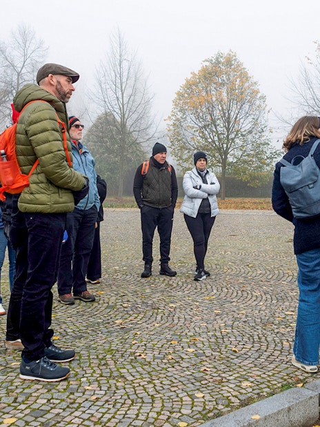 Tour guide explaining to tourists during Terezin Concentration Camp tour.